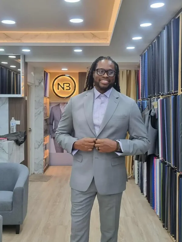 Client wearing light grey tailored suit inside showroom